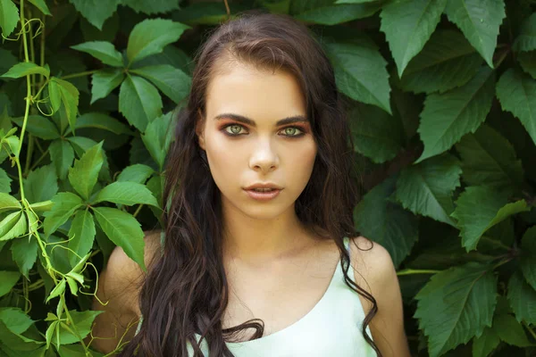 Retrato de uma jovem menina bonita em folhagem hera verde — Fotografia de Stock