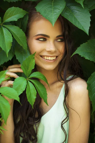 Portré egy fiatal szép lány, zöld borostyán lombozat — Stock Fotó