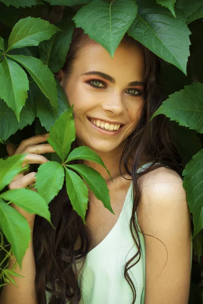 Retrato de uma jovem menina bonita em folhagem hera verde — Fotografia de Stock