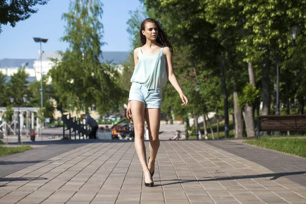 Jovem bela mulher morena em uma blusa azul e shorts walki — Fotografia de Stock