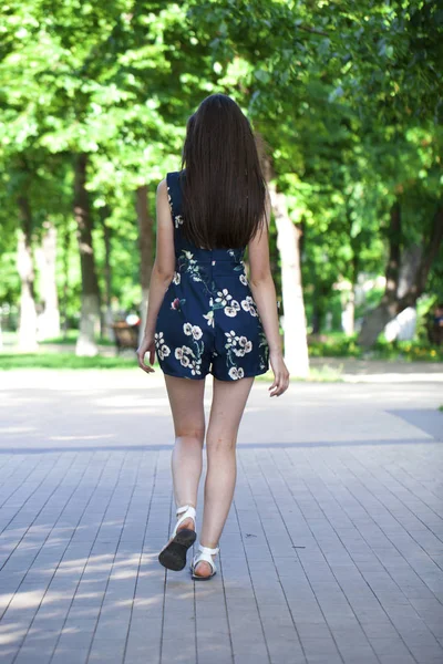 Joven hermosa mujer en un vestido corto azul caminando por el camino — Foto de Stock