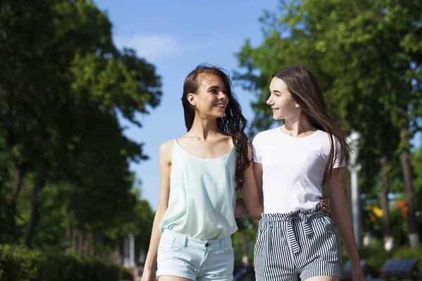 Två flick vänner som går på sommar gatan, utomhus — Stockfoto