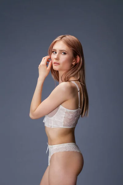 Sexy jonge blonde vrouw poseren in wit ondergoed — Stockfoto