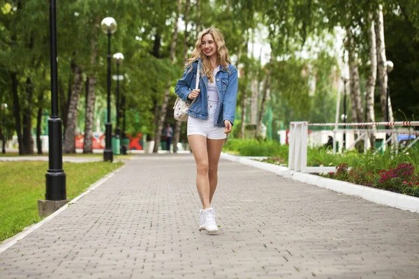 Schöne sexy blonde Frau in Jeansjacke und kurzer Hose — Stockfoto