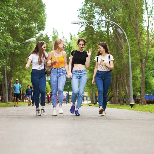 Щасливі жінки в блакитних джинсах, що ходять в літньому парку — стокове фото
