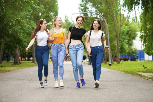 Happy women in blue jeans walking in summer park — Stock Photo, Image