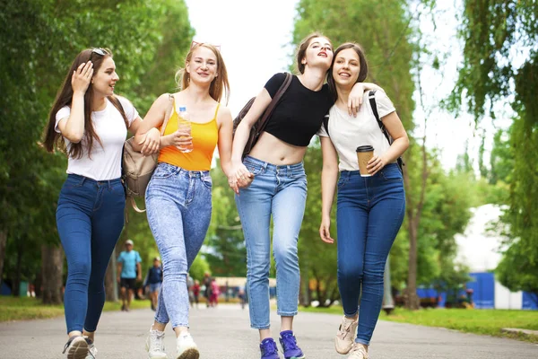 Happy women in blue jeans walking in summer park — Stock Photo, Image