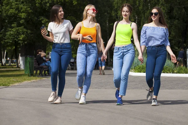 Donne felici in jeans blu che camminano nel parco estivo — Foto Stock
