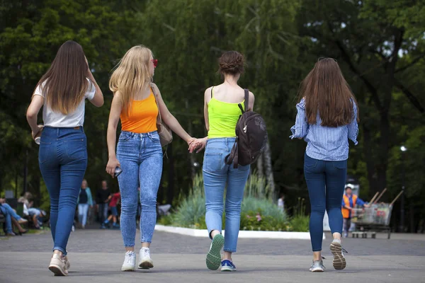 Mulheres felizes em jeans azuis andando no parque de verão — Fotografia de Stock