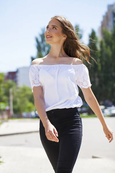 Giovane bella donna bruna in jeans e camicetta bianca a piedi — Foto Stock