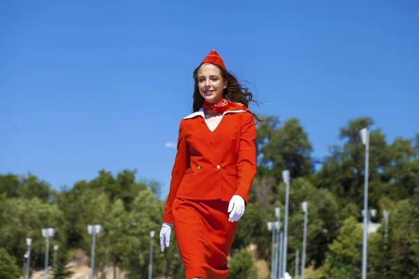 Hermosa azafata vestida con uniforme oficial rojo gjalá bl — Foto de Stock