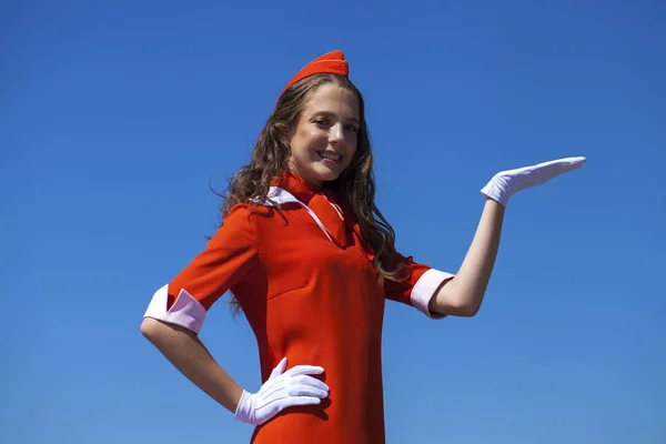Bella hostess vestita in uniforme rossa ufficiale gascar a bl — Foto Stock