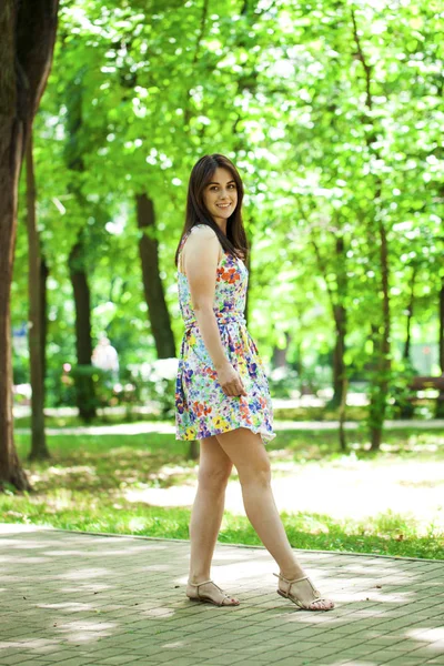 Νεαρή όμορφη γυναίκα με φόρεμα στο καλοκαιρινό πάρκο — Φωτογραφία Αρχείου
