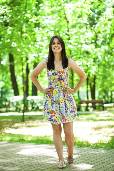 Νεαρή όμορφη γυναίκα με φόρεμα στο καλοκαιρινό πάρκο — Φωτογραφία Αρχείου