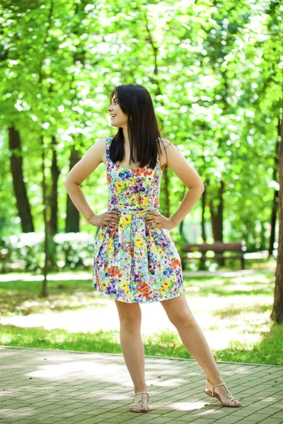 Jonge mooie vrouw in jurk in het zomerpark — Stockfoto