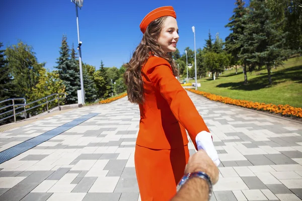 Follow me young stewardess in red uniform — Stock Photo, Image