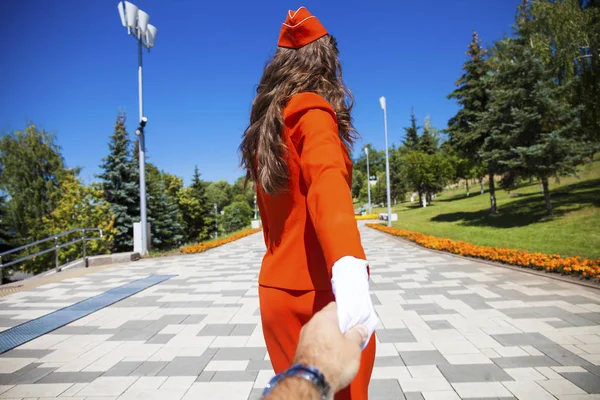 Volg mij jonge stewardess in rood uniform — Stockfoto