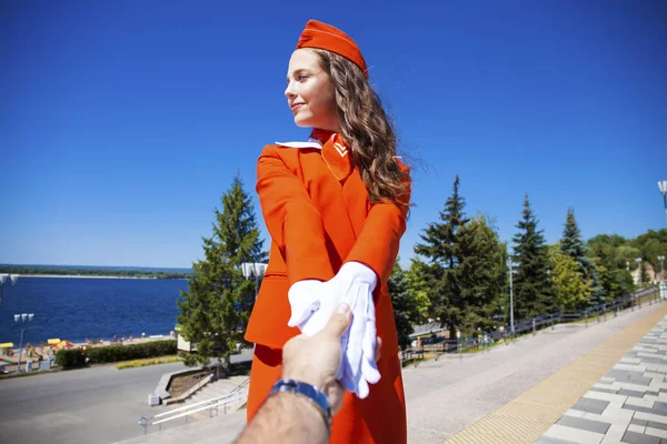 Follow me young stewardess in red uniform — Stock Photo, Image