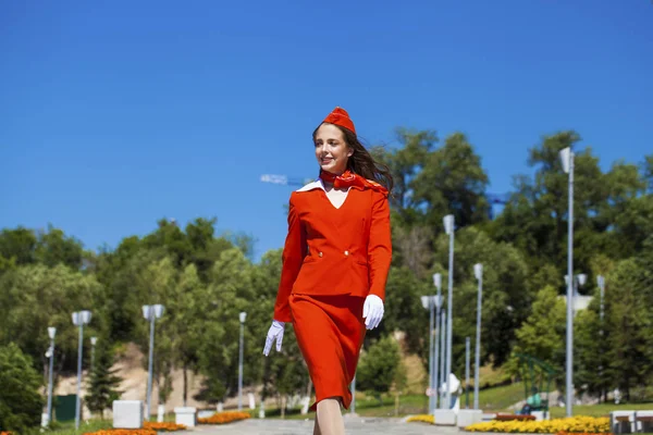 Bella hostess vestita in uniforme rossa ufficiale gascar a bl — Foto Stock