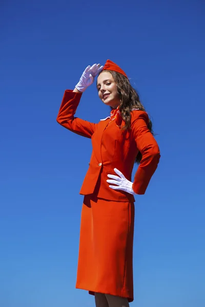 Hermosa azafata vestida con uniforme oficial rojo gjalá bl — Foto de Stock