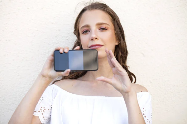 Schöne Mädchen zeigt Ihren Smartphone-Bildschirm — Stockfoto