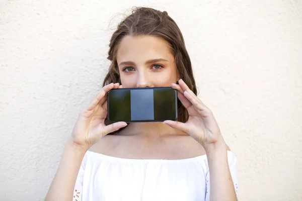 Schöne Mädchen zeigt Ihren Smartphone-Bildschirm — Stockfoto