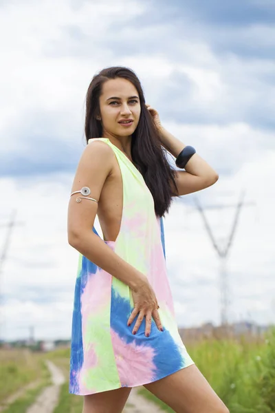 Young beautiful woman in colored tunic posing against the backgr — Stock Photo, Image