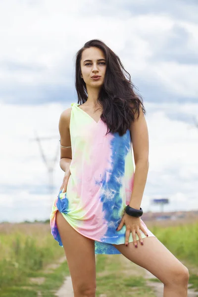 Young beautiful woman in colored tunic posing against the backgr — Stock Photo, Image