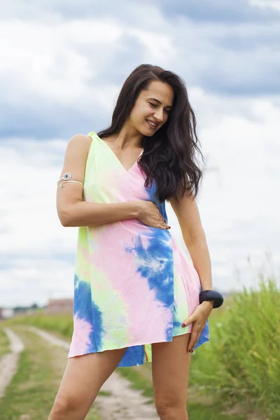 Young beautiful woman in colored tunic posing against the backgr — Stock Photo, Image