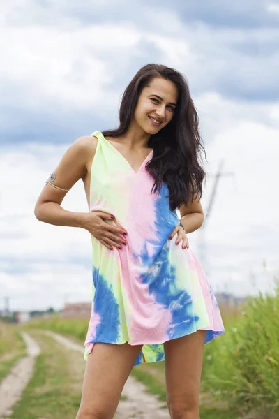 Młoda piękna kobieta w kolorowej tuniki stwarzające przeciwko ekspresyjne — Zdjęcie stockowe