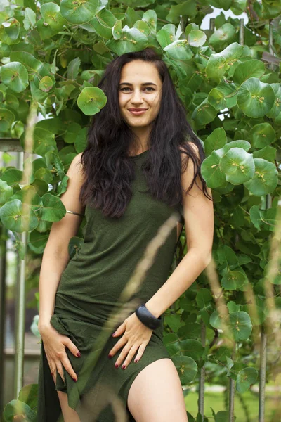 Retrato de uma jovem mulher bonita em folhagem verde — Fotografia de Stock
