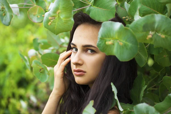 Portret młodej pięknej kobiety w zielonych liści — Zdjęcie stockowe