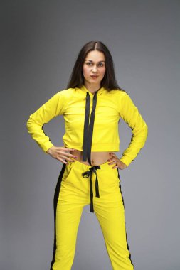 Sarı eşofmanlı genç ve güzel esmer bir kadının portresi