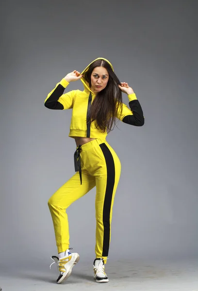 Portrait of a young beautiful brunette woman in yellow tracksuit — Stock Photo, Image