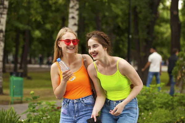 Twee vriendinnen wandelen op zomerpark, buitenshuis — Stockfoto