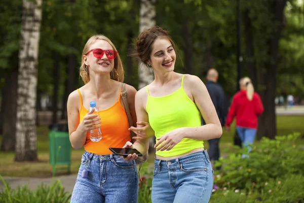 Two girlfriends walking on summer park, outdoors — Stock Photo, Image