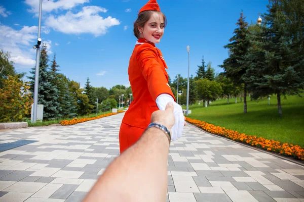 Follow Me, Młoda stewardessa ubrana w oficjalny czerwony mundur — Zdjęcie stockowe