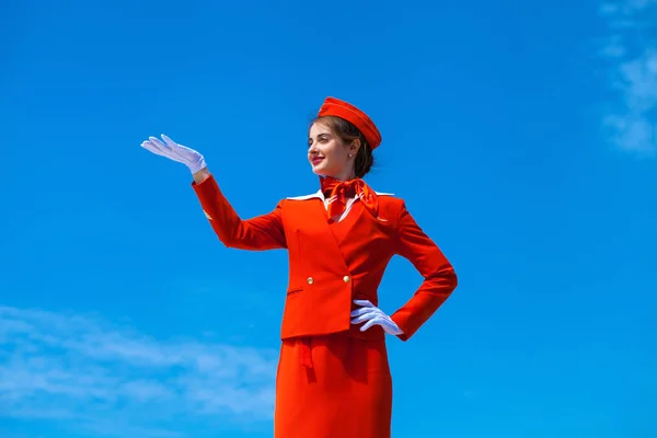 Young stewardess dressed in official red uniform of Airlines — Stock Photo, Image