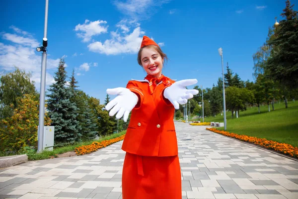 Joven azafata vestida con uniforme oficial rojo de Airlines — Foto de Stock