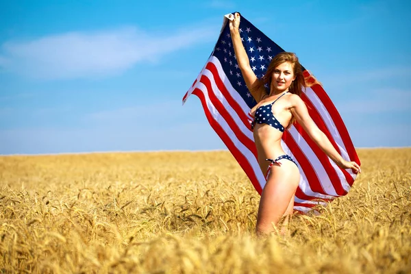 Сексуальная женщина в сексуальном американском бикини под флагом на пшеничном поле — стоковое фото