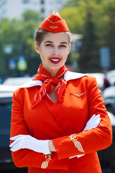 Młoda stewardessa ubrana w oficjalny czerwony mundur linii lotniczych — Zdjęcie stockowe
