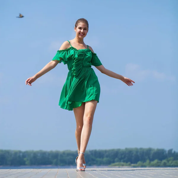 Fiatal gyönyörű nő, zöld ruhában séta a nyári Stree — Stock Fotó