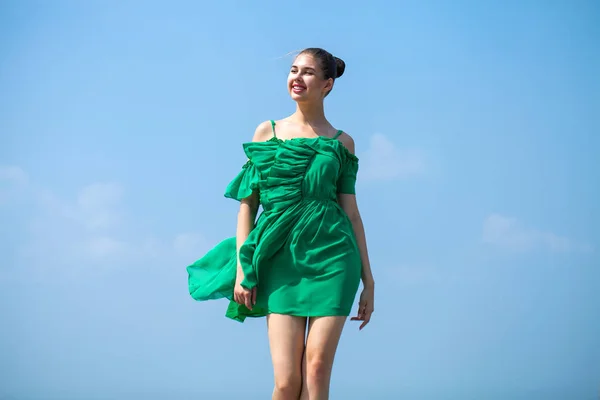 Jeune belle femme en robe verte marchant sur le stree d'été — Photo