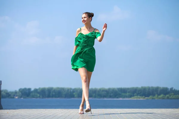 Jovem mulher bonita em vestido verde andando sobre a árvore de verão — Fotografia de Stock