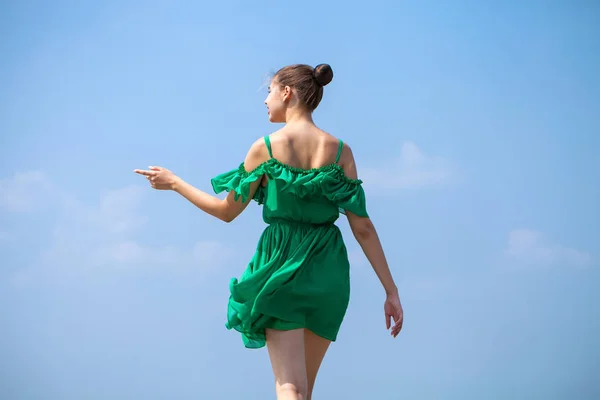 Young beautiful brunette girl in green dress walks along the emb — Stock Photo, Image