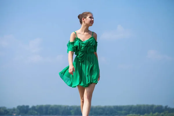 Young beautiful woman in green dress walking on the summer stree — Stock Photo, Image