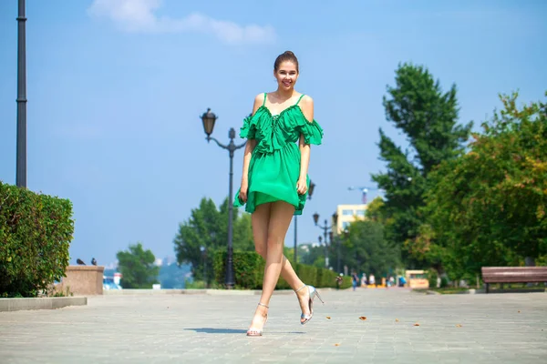 Jovem mulher bonita em vestido verde andando sobre a árvore de verão — Fotografia de Stock