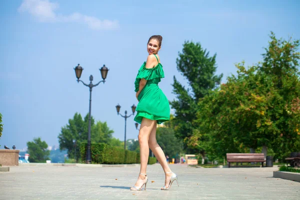 여름 나무에 걷는 녹색 드레스에 젊은 아름다운 여자 — 스톡 사진