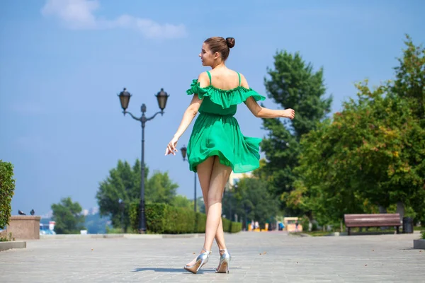 Young beautiful brunette girl in green dress walks along the emb — Stock Photo, Image