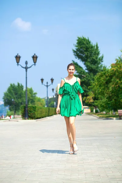 Fiatal gyönyörű nő, zöld ruhában séta a nyári Stree — Stock Fotó